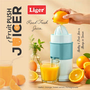 Liger fruit push juicer with oranges and juice on a wooden surface