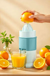 Person using a manual juicer to extract juice from oranges on a wooden table.